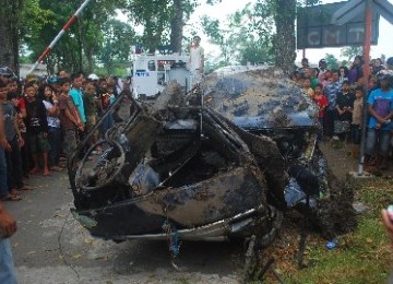 Petugas mengevakuasi mobil jenis Suzuki Carry bernomor polisi Z951W yang tertabrak Kereta Api Pasundan Jurusan Bandung–Surabaya, di perlintasan rel tanpa palang pintu di Kampung Sindangkasih, Kelurahan Sukanegara, perbatasan Kecamatan Cibeureum-Purbaratu, 