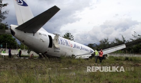 Petugas mengevakuasi pesawat kargo jenis boeing 737-301F dengan kode lambung PK-YGG milik maskapai penerbangan Tri-MG Asia Airlines yang tergelincir di Bandara Wamena, Wamena, Papua, Selasa (18/7). 