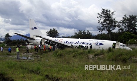 Petugas mengevakuasi pesawat kargo jenis boeing 737-301F dengan kode lambung PK-YGG milik maskapai penerbangan Tri-MG Asia Airlines yang tergelincir di Bandara Wamena, Wamena, Papua, Selasa (18/7).