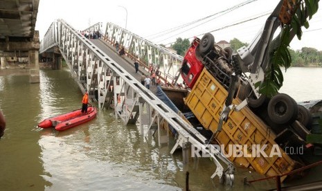 Petugas mengevakuasi truk di lokasi jembatan Widang yang runtuh, Tuban, Jawa Timur, Selasa (17/4). 