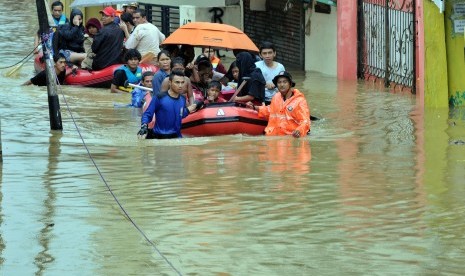 Petugas mengevakuasi warga dari banjir yang melanda permukiman di Cawang, Jakarta Timur