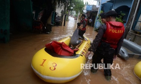 Petugas mengevakuasi warga denga perahu karet saat banjir melanda Kelurahan Cipinang Melayu, Kecamatan Makassar, Jakarta Timur, Senin (20/2). 