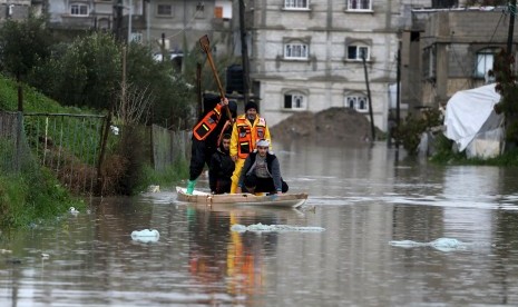 Petugas mengevakuasi warga di wilayah banjir di Jalur Gaza, Palestina, Selasa (26/1). 