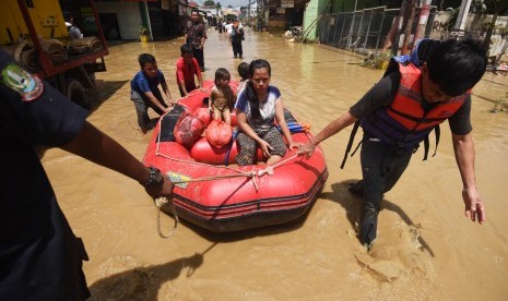 Petugas mengevakuasi warga yang sakit saat banjir melanda kawasan Perumahan Pondok Gede Permai, Jatiasih, Bekasi, Jawa Barat, Jumat (22/4).  (Antara/Akbar Nugroho Gumay)