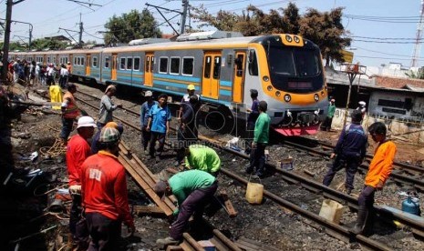 Petugas mengganti rel kereta api yang rusak akibat tabrakan kereta api dengan truk tangki di perlintasan kereta di Bintaro Permai, Jakarta Selatan, Selasa (10/12).   (Republika/Yasin Habibi)