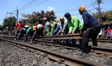 Petugas mengganti rel kereta api yang rusak akibat tabrakan kereta api dengan truk tangki di perlintasan kereta di Bintaro Permai, Jakarta Selatan, Selasa (10/12).   (Republika/Yasin Habibi)