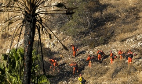 Petugas menggarap batas api di perbukitan di West Hills, Kalifornia, (12/11). Kebakaran hutan menghabiskan lahan seluas puluhan hektare.