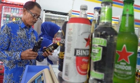 Petugas menggelar razia minuman beralkohol di sebuah minimarket di Kota Madiun, Jumat (30/1).