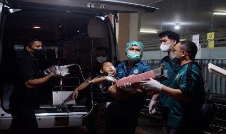 Petugas menggendong seorang anak korban gempa di lapangan RSUD Sayang, Kabupaten Cianjur, Jawa Barat, Senin (21/11/2022).