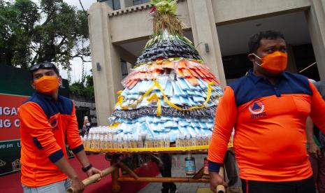 Petugas menggotong gunungan prokes di Teras Malioboro I, Yogyakarta, Selasa (11/10/2022). Larung gunungan prokes yang digelar BPBD DIY tersebut untuk mengingatkan kembali penerapan protokol kesehatan terutama bagi wisatawan di kawasan Malioboro. 