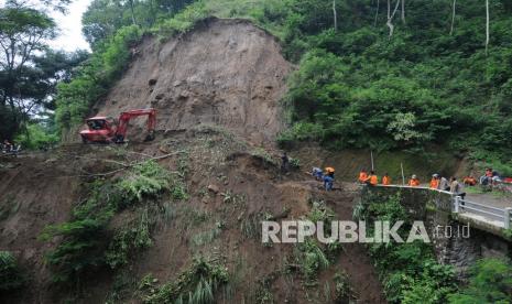 Petugas menggunakan alat berat membersihkan tanah longsor yang menutupi akses jalan di lereng Merapi, Sangup, Tamansari, Boyolali, Jawa Tengah, Senin (17/1/2022). Intensitas curah hujan tinggi membuat kontur tanah tebing di daerah tersebut longsor dan menutupi akses jalan desa. 