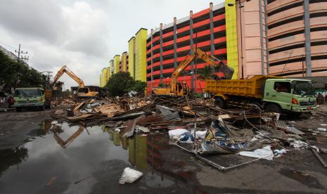 Petugas menggunakan alat berat membongkar tempat penampungan sementara (TPS) Pasar Turi, Surabaya, Jawa Timur, Selasa (22/3/2022). Tempat penampungan sementara (TPS) yang merupakan tempat berjualan sementara bagi pedagang Pasar Turi pascakebakaran itu kini dibongkar karena gedung Pasar Turi Baru telah siap ditempati.