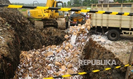 Petugas menggunakan alat berat untuk memusnahkan rokok ilegal di Tempat Pembuangan Akhir (TPA) Tanjungrejo, Kudus, Jawa Tengah, Kamis (12/12/2018). 