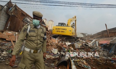  Petugas menggunakan eskavator meratakan bangunan saat penertiban yang dilakukan di Pasar Ikan Penjaringan, Jakarta Utara, Senin (11/4). (Republika/Raisan Al Farisi)