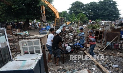 Petugas menggunakan kendaraan alat berat saat membongkar bangunan liar di kawasan TPU Menteng Pulo, Jakarta Selatan, Kamis (7/4).  (Republika/Yasin Habibi)