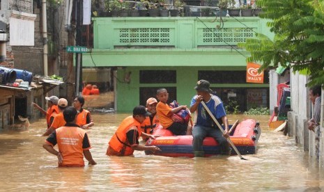 Petugas menggunakan perahu karet membawa warga melewati banjir yang merendam di kawasan Rawajati Kalibata, Jakarta, Selasa (8/3).