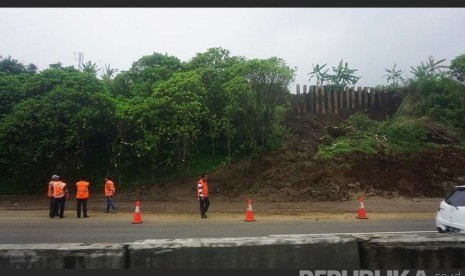  Petugas menggunakan peralatan eskavator berjaga di km 118 Tol Cikamuning arah ke Bandung, Ahad (10/4). (Republika/Yogi Ardhi)