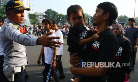 [Ilustrasi] Petugas menghalau warga yang menggunakan atribut bernuansa politik memasuki arena Car Free Day arena tidak sesuai dengan Pergub No.12 tentang larangan melakukan kegiatan politik diacara dan tempat berlangsungnya Hari Bebas Kendaraan Bermotor atau Car Free Day (CFD) di Jakarta, Ahad (6/5).