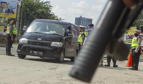 Petugas menghentikan kendaraan roda empat di titik pemeriksaan PSBB. Ilustrasi