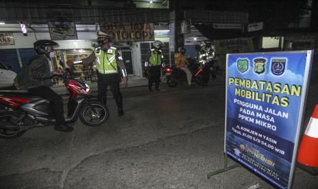 Petugas menghentikan pengendara yang masih melintas saat pembatasan mobilitas di Jalan Komjen M Yasin, Depok, Jawa Barat, Selasa (29/6/2021). Polda Metro Jaya menambah lokasi pembatasan mobilitas selama Pemberlakuan Pembatasan Kegiatan Masyarakat (PPKM) berskala mikro menjadi 21 lokasi yang meliputi Jakarta, Depok, Tangerang, dan Bekasi.