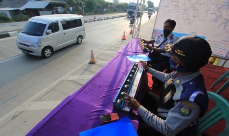 Petugas menghitung kendaraan yang melintas di Jembatan Timbang, Losarang, Indramayu, Jawa Barat, Jumat (8/6).