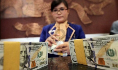 Petugas menghitung mata uang dollar Amerika, di Kantor Bank BRI, Jakarta, Kamis (3/7).(Republika/Adhi Wicaksono).