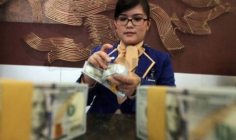 Petugas menghitung mata uang dollar Amerika, di Kantor Bank BRI, Jakarta, Kamis (3/7).(Republika/Adhi Wicaksono).