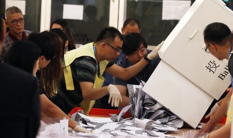 Petugas menghitung surat suara dalam Pemilu di Hong Kong pada Ahad (24/11). 