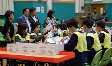 Petugas menghitung surat suara dalam Pemilu di Hong Kong pada Ahad (24/11). 