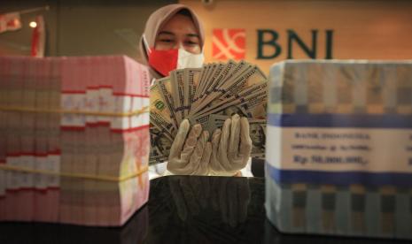 Petugas menghitung uang dolar AS dan uang Rupiah di salah satu kantor cabang PT Bank Negara Indonesia (Persero) Tbk, KCU Melawai, Jakarta. Nilai tukar rupiah terhadap dolar Amerika Serikat (AS) masih melemah pada Kamis (22/9/2022) pagi. Kurs tukar rupiah terhadap dolar AS per Kamis pagi tercatat sebesar Rp 15.054.