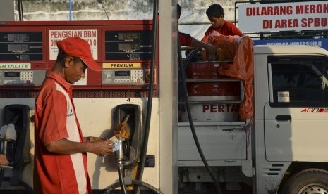 Petugas menghitung uang hasil penjualan bahan bakar minyak (BBM) di SPBU Ni'u, Bima, NTB, Minggu (25/12). 