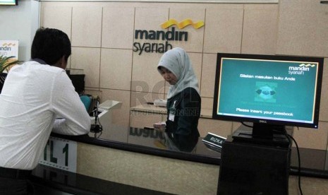 Petugas menghitung uang nasabah di banking hall salah satu kantor cabang Bank Syariah Mandiri, Jakarta, Jumat (4/7).  (Republika/Adhi Wicaksono)