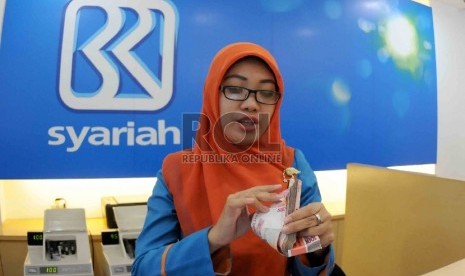  Petugas menghitung uang nasabah di salah kantor Bank BRI Syariah, Jakarta, Kamis (20/8). 