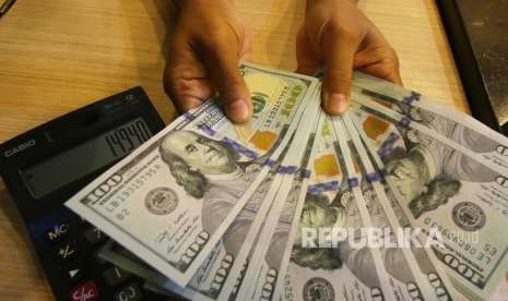 Petugas menghitung uang pecahan dolar Amerika Serikat di gerai penukaran mata uang asing. ilustrasi