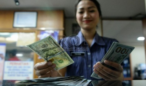 Petugas menghitung uang pecahan Dolar AS di salah satu tempat penukaran uang, Jakarta, Kamis (23/4).  (Republika/Prayogi)