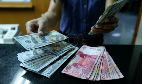 Petugas menghitung uang pecahan Dolar AS di salah satu tempat penukaran uang, Jakarta, Kamis (23/4).  (Republika/Prayogi)