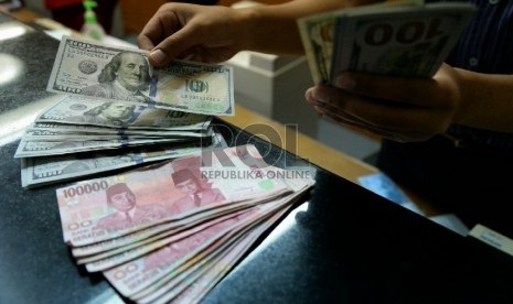 Petugas menghitung uang pecahan Dolar AS di salah satu tempat penukaran uang, Jakarta, Kamis (23/4).  (Republika/Prayogi)