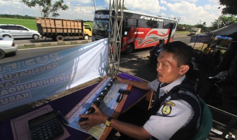 Petugas menghitung volume kendaraan yang melintas di Jalur Pantura Lohbener, Indramayu, Jawa Barat.