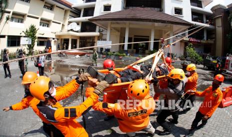 Petugas mengikuti simulasi bencana gempa saat Hari Kesiapsiagaan Bencana di Balai Kota Solo, Jawa Tengah, Senin (26/4/2021). Simulasi yang melibatkan Polisi, TNI, SAR, PMI, PNS dan relawan tersebut bertujuan untuk melatih kesiapan dan kesigapan menghadapi musibah bencana gempat. 