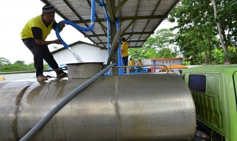 Petugas mengisi air ke dalam truk tangki air minum di tempat pengisian air di Cendono, Kudus, Jawa Tengah, Rabu (23/3).