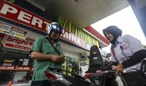 Petugas mengisi Bahan Bakar Minyak (BBM) kedalam tangki kendaraan roda dua di Stasiun Pengisian Bahan Bakar Umum (SPBU) Koko Kenten Palembang, Sumatera Selatan, Sabtu (5/1/2019).