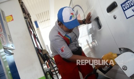 Petugas mengisi BBM di SPBU COCO Pertamina, Jakarta, Ahad (25/9).