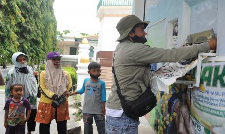 Petugas mengisi karung beras yang akan dibagikan pada warga membutuhkan di halaman Masjid Agung Palembang, Sumatera Selatan, Senin (4/10/2021). Humanity Rice Truck Aksi Cepat Tanggap (ACT) yang didesain layaknya anjungan tunai mandiri dengan kapasitas 20 ton beras ini membagikan beras bagi ratusan warga membutuhkan di empat kota/ kabupaten di Sumatra Selatan kemudian dilanjutkan ke Sumatra Barat.