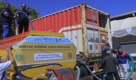 Petugas mengisi minyak goreng curah ke dalam mobil tangki yang diambil dari satu unit kontainer usai acara pendistribusian minyak goreng curah dan gula pasir di Kupang, NTT, Rabu (11/5/2022). BUMN Holding pangan ID FOOD bersama Kementerian Perhubungan, Badan Pangan Nasional, PTPN Group, Pos Indonesia dan BRI bersinergi mulai mendistribusikan 800 ton gula pasir dan 300 ton minyak goreng curah ke pasar - pasar tradisional di Kupang.