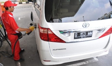 Petugas mengisikan bahan bakar minyak (BBM) bersubsidi atau premium pada mobil mewah di sebuah stasiun pengisian BBM umum (SPBU) di Cikini, Jakarta Pusat, Senin (2/4). 