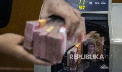 Petugas mengitung uang rupiah di salah satu gerai penukaran uang asing di Jakarta, Rabu (27/11). Nilai tukar (kurs) rupiah yang ditransaksikan antarbank di Jakarta pada Kamis (12/3) pagi melemah pasca Organisasi Kesehatan Dunia (WHO) menyatakan COVID-19 sebagai pandemik. 