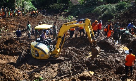 Petugas mengoperasikan alat berat guna mencari korban tanah longsor di Caok, Karangrejo, Loano, Purworejo, Jateng, Senin (20/6).