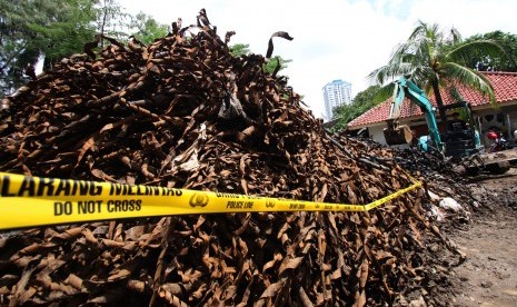 Petugas mengoperasikan alat berat guna merapikan tumpukan sampah kulit kabel listrik di tempat penampungan gudang kendaraan berat Sudin Tata Air Jakarta Pusat, Bendungan Hilir, Jakarta, Kamis (3/3).