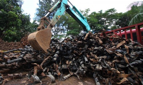 Petugas mengoperasikan alat berat guna merapikan tumpukan sampah kulit kabel listrik di tempat penampungan gudang kendaraan berat Sudin Tata Air Jakarta Pusat, Bendungan Hilir, Jakarta, Kamis (3/3).