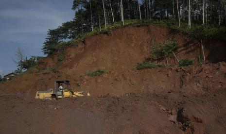 Petugas mengoperasikan alat berat saat evakuasi material longsor di Kabupaten Cianjur, Jawa Barat